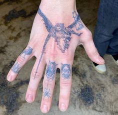 a person's hand with tattoos on it