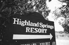 black and white photograph of a sign for highland springs resort with trees in the background