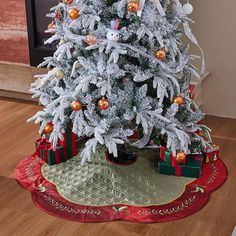 a white christmas tree with presents under it