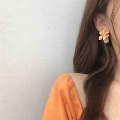 a close up of a person wearing earrings with flowers on it's earring