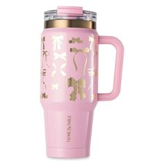 thermos travel mug in pink with gold flowers and bows on it, is shown