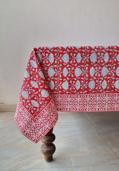 a red and white table cloth sitting on top of a wooden stand