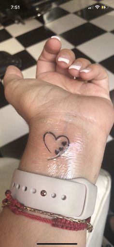 a person with a heart tattoo on their wrist