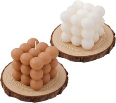 two candles made out of wood with white and brown balloons on top of each candle