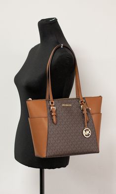 Style: Michael Kors Charlotte Handbag Tote (Brown Signature) Material: PVC/Leather Features: MK Logo on Front, Zip Closure, MK logo charm, Exterior Pocket Measures: 10" L x 15" W x 4.5" D MSRP: $398 Luxury Tote Bags Michael Kors, Michael Kors Shopper Bag, Michael Kors Brown Tote, Cheap Rectangular Michael Kors Shoulder Bag, Cheap Michael Kors Rectangular Shoulder Bag, Brown Business Bag With Logo, Brown Tote Shoulder Bag With Logo, Brown Logo Tote Shoulder Bag, Brown Double Handle Shoulder Bag With Logo