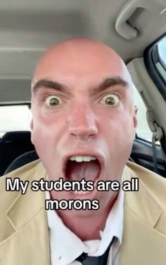 a man with his mouth open in the back seat of a car, saying my students are all morons