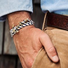 a close up of a person wearing a bracelet with an anchor on it's wrist