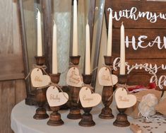 a table topped with lots of candles next to a wooden sign