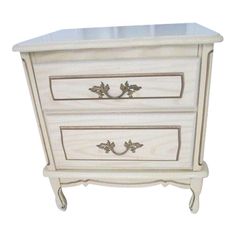 a white dresser with two drawers on it