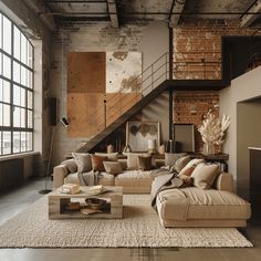 a living room filled with lots of furniture next to a stair case in an industrial building