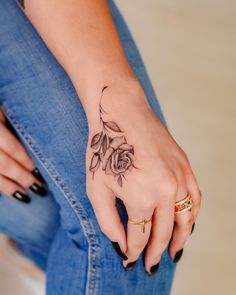 a woman's hand with a rose tattoo on it