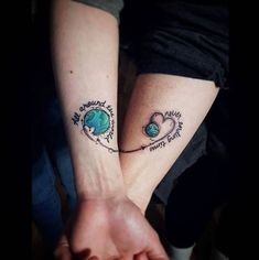 two people are holding hands with tattoos on their arms and one has a heart in the middle