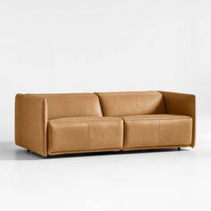 a brown leather couch sitting on top of a white floor