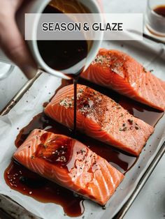 the salmon is being drizzled with sauce on it and placed in a pan