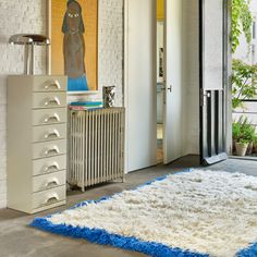 a white and blue rug is in the middle of a room with an open door