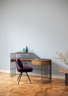 a purple chair sitting in front of a desk with a plant on top of it