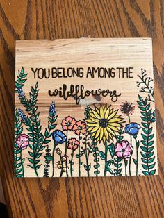 a wooden sign that says, you belong among the wildflowers