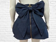 "This fun twist on your denim skirt features a high waistband trimmed with metallic gold bias tape, a mini tulip shaped bottom and is finished off with a large center back bow to add a bit of high fashion drama. From waist to hem the skirt measures 20\" long Zipper color may change ( silver or gold ) depending on availability.  There are two available. One small and one medium PLEASE view size chart provided before placing your order There are no returns on this custom item, even exchange or merchandise credit only." High Waist Denim Skirt, Bow Jeans, Skirt With Bow, Skirt Bow, Jean Mini Skirt, Bow Skirt, High Waisted Denim Skirt, Jean Mini Skirts, High Waist Denim