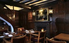 a dining room with wooden tables and chairs next to a fire place in the fireplace