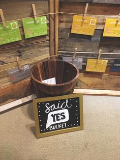 a wooden bucket sitting on top of a floor next to a sign that says solid yes bucket