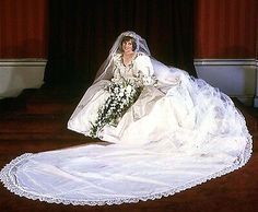 a bride sitting on the floor with her wedding dress and bouquet in front of her