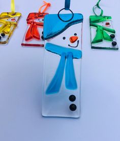 three glass ornaments with snowmen on them