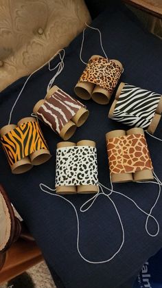 several rolls of paper wrapped in animal print sitting on top of a blue table cloth