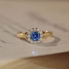 a blue and white diamond ring sitting on top of a piece of paper