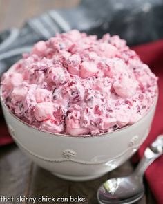 cranberry fluff salad in a white bowl with spoons on the side