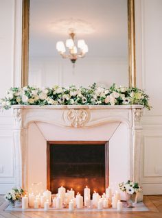 the fireplace is decorated with flowers and candles