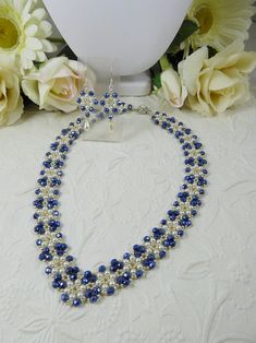 a blue and white beaded necklace next to flowers