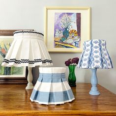 two lamps are sitting on a table next to pictures