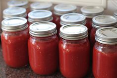 several jars filled with red sauce sitting on top of a counter