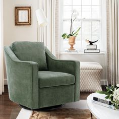 a living room with a green chair in front of a window and a rug on the floor