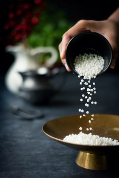 a person pouring white rice into a gold plate