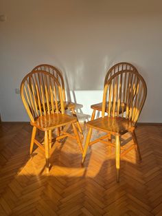 two wooden chairs sitting on top of a hard wood floor