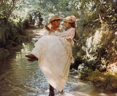 a man carrying a woman across a river