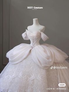 a white wedding dress on display in front of a mannequin's head