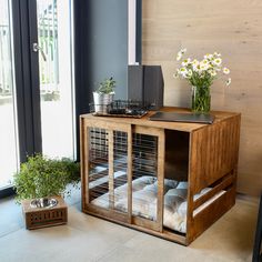 a dog crate with flowers and pillows in it