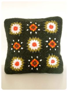 a crocheted pillow with flowers on it