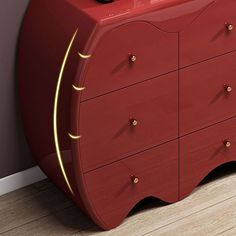 a red dresser sitting on top of a hard wood floor