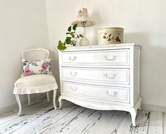 ATTENTION!! MUST NEED SHIPPING QUOTE! This dresser is from the original Shabby Chic Couture by Rachel Ashwell. Shabby chic Slate white wooden painted dresser with chippy perfection. This piece is one of a kind and rare treasure. Dresser features solid wood design, has three drawers for storage, well kept and original cast iron drawer handle hardware. There is an original Rachel Ashwell signature pattern liner in the drawer. The dresser has the Copper Shabby Chic tag on the back.  There are five dime-sized marks on the top. These cannot be removed. If removed, it will cause damage to the wooden top. The previous owner said he had set a TV on it for a long time. There are a few thin cracks on the drawers, but these are natural cracks. There is no problem with function  The dresser has been d White Vintage Dressers, White Vintage Dresser, Distressed White Dresser Shabby Chic, White Princess Dresser, Cowuette Dresser, Shabby Chic Tags, Handle Hardware, Solid Wood Design, Rachel Ashwell Shabby Chic