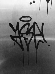 black and white photograph of graffiti on a metal surface