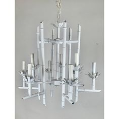 a chandelier made out of white pipes and sticks with birds on them hanging from the ceiling