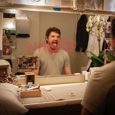 a man sticking his tongue out in front of a mirror with the word where on it