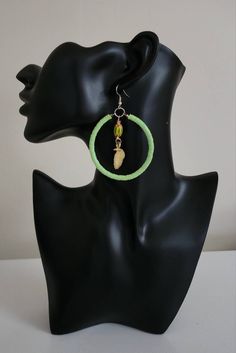 Accessorize your outfit with this unique African Beaded Hoop Earring. It is designed with a chevron bead, and brass leaf. Measures 2 inches in diameter. Hook backs. Light weight. Single Green Hoop Earring, Unique Green Hoop Earrings, Unique Green Hoop Jewelry, Green Hoop Earrings With Dangling Beads, Adjustable Green Hoop Earrings, Green Hoop Earrings For The Beach, Green Hoop Earrings For Beach, Green Hoop Earrings With Ear Wire, Handmade Adjustable Green Hoop Earrings