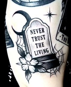 a black and white photo of a tattoo with the words never trust the living on it