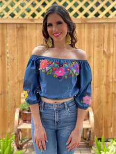 This Beautiful Off the Shoulder Crop Top is the perfect Top for a fun day out. It's made out of fine, soft denim and has elastic around the waist. The floral design is hand embroidered. This blouse is hand embroidered and the embroidered colors vary on each blouse making each blouse one of a kind. More colors available here: https://www.etsy.com/es/listing/855531148/crop-top-manga-larga-blusa-artesanal?ref=listings_manager_grid Purchase the Artisanal Mexican earrings modeled here: https://www.et Cute Multicolor Embroidered Tops For Spring, Cute Multicolor Embroidery Tops For Spring, Cute Embroidered Summer Tops, Cute Embroidered Tops For Spring, Cute Embroidered Spring Tops, Cute Fitted Blouse With Floral Embroidery, Cute Multicolor Embroidered Tops For Summer, Cute Multicolor Embroidered Tops, Mexican Outfits For Women