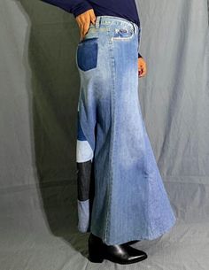 a woman is standing with her back to the camera wearing a blue jean skirt and black booties