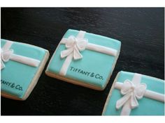 three decorated cookies sitting on top of a table